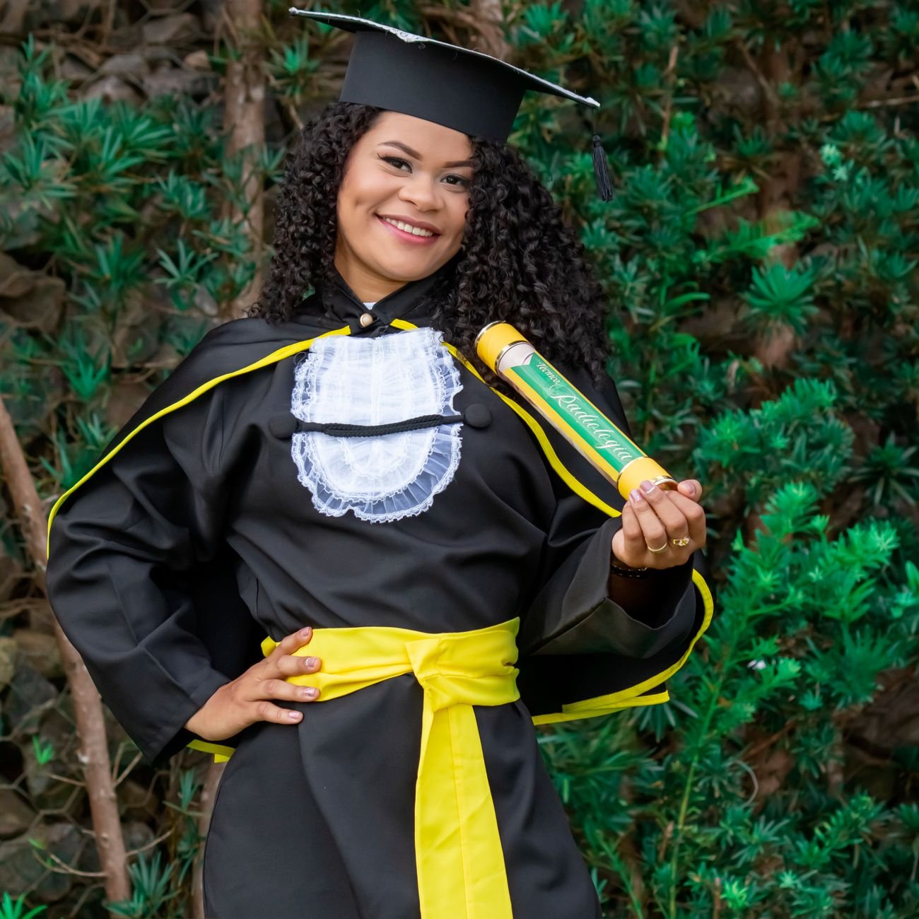 Young woman celebrating graduation with cap and diploma.